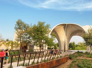 Two women running toward the large structure at Confluence Park.
