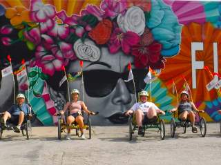 Cyclists on bike tour in front of San Antonio mural