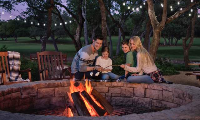 Family sitting be campfire outside