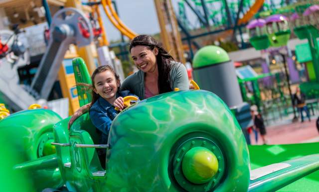 Mother and daughter smiling on Green Lantern ride at Six Flags Fiesta Texas.