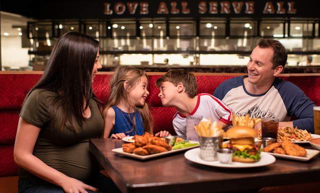 Family laughing and enjoying dinner at Hard Rock Cafe San Antonio.