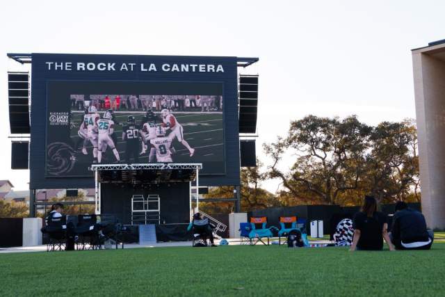 people watching game on big screen outside