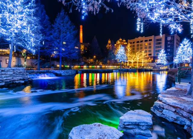 Museum Reach portion of River Walk lit up with blue-hued holiday lights.