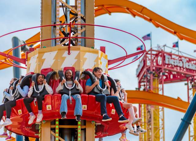 People on Shazam-themed drop tower ride at Six Flags Fiesta Texas.