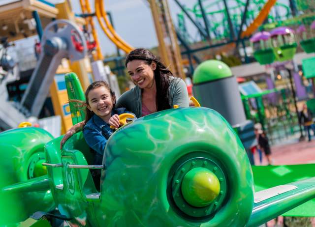Mother and daughter smiling on Green Lantern ride at Six Flags Fiesta Texas.