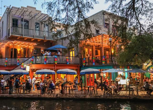 People dining along the San Antonio River Walk.