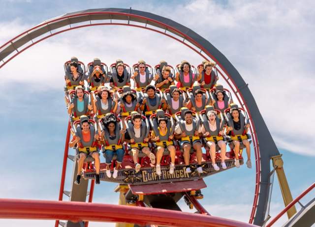 Dr. Diabolical's Cliffhanger roller coaster with three rows of people harnessed in at Six Flags Fiesta Texas.