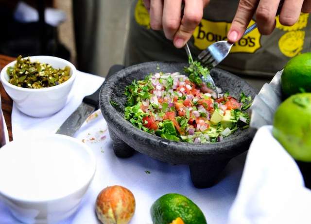 Guacamole being made in a molcajete