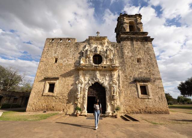 Woman standing in front of San Antonio Mission