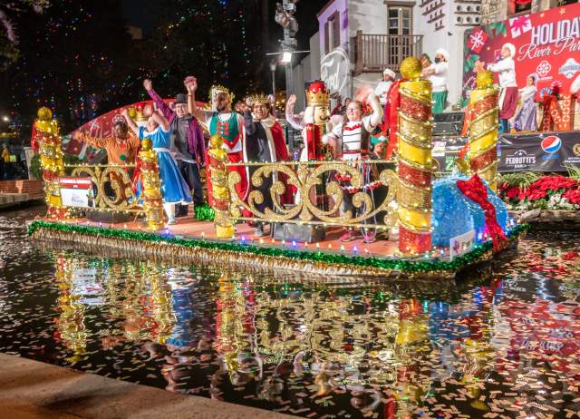 Festive decorated float with costumed patrons at Ford Holiday River Parade.