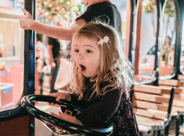 Little girl playing on trolley at The DoSeum.