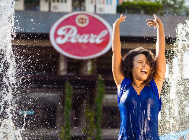 Woman splashing in fountain at Pearl in San Antonio.