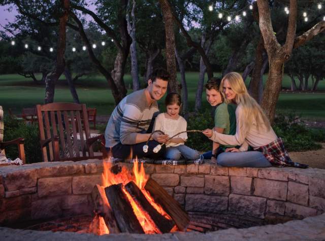 Family sitting be campfire outside