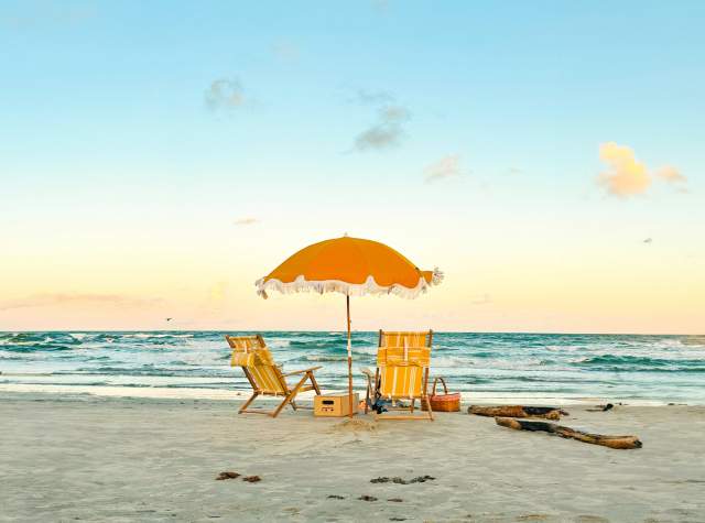 Beach with two yellow chairs and matching yellow umbrella