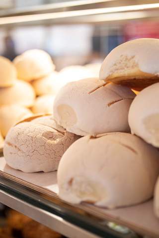 Conchas stacked on top of each other in display case at La Panaderia.
