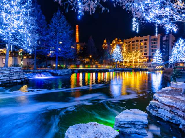 Museum Reach portion of River Walk lit up with blue-hued holiday lights.