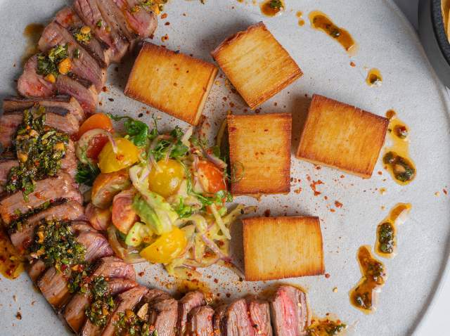 Overhead view of plated steak and frites at Esencia at St. Anthony hotel in San Antonio.