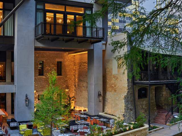 Exterior view of Canopy by Hilton - San Antonio Riverwalk hotel with patio dining on San Antonio River Walk.