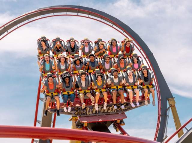 Roller coaster with three rows of people harnessed in