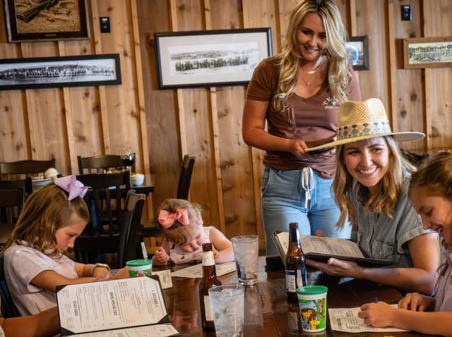 Family sitting at table ordering food at Tejas Rodeo.
