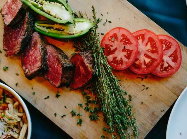 Overhead view of cutting board with steak and veggies