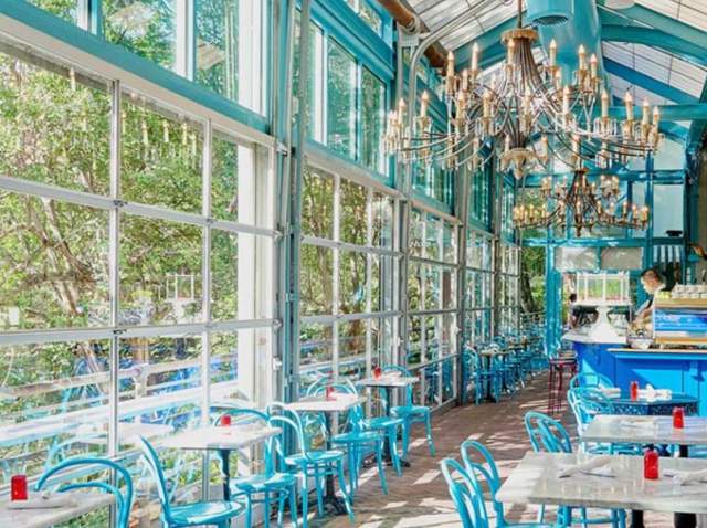 Blue dining area at Ocho at Hotel Havana with chandelier and blue accents.