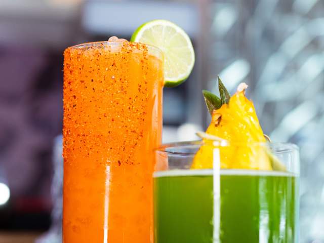 Two tropical cocktails side-by-side.