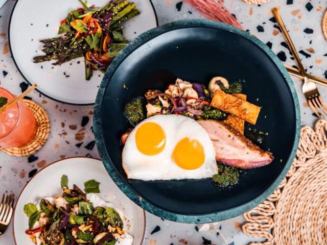 Overhead view of bowl will over easy egg and side salads