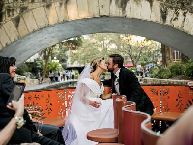Bride and groom on river barge kissing