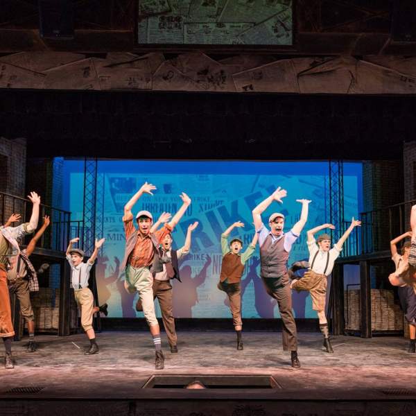 Actors dancing in performance of "Newsies"