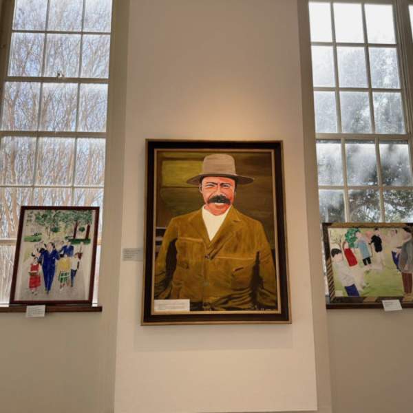 Painting of man in a hat hung on wall
