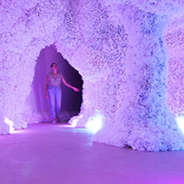 Woman walking through brightly lit cave