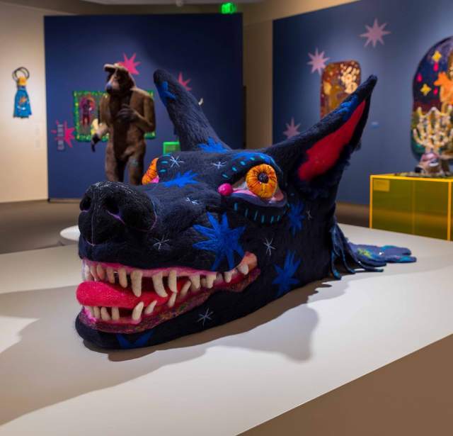 wolf head made out of threads on display in museum exhibit