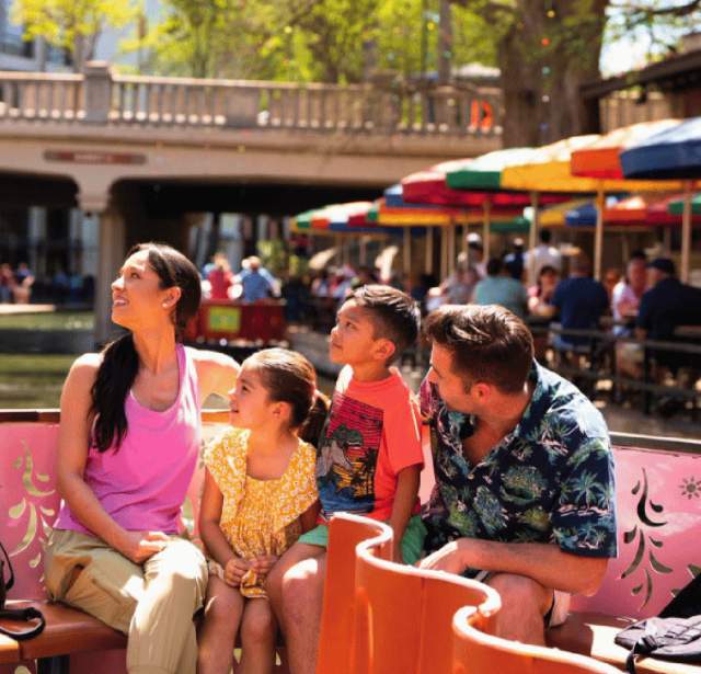 family on river walk barge on the San Antonio River Walk