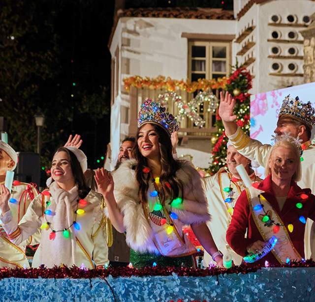 People dressed as fake royalty with holiday light necklaces