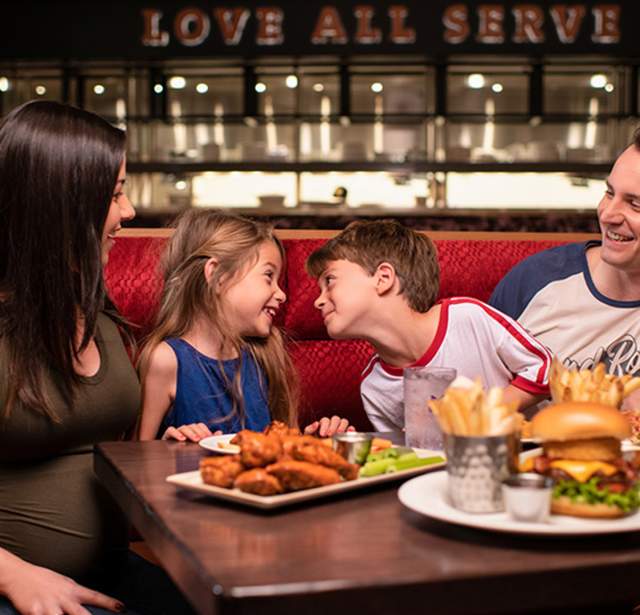 Family laughing and enjoying dinner at Hard Rock Cafe San Antonio.