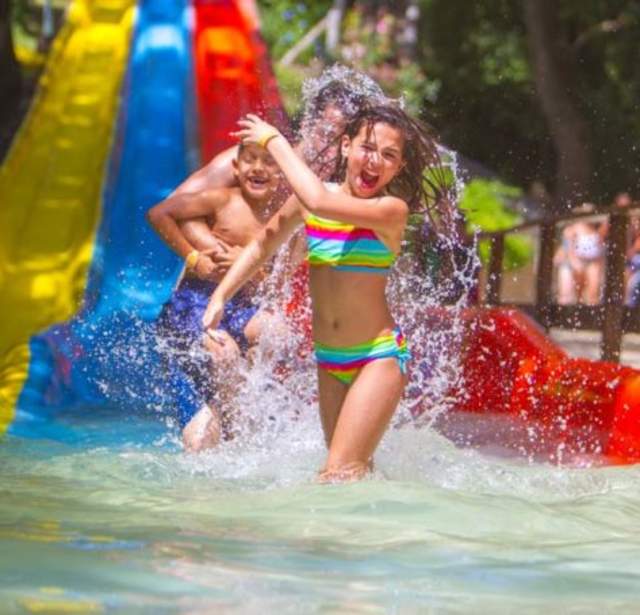 Girl walking away from waterslide splashing water