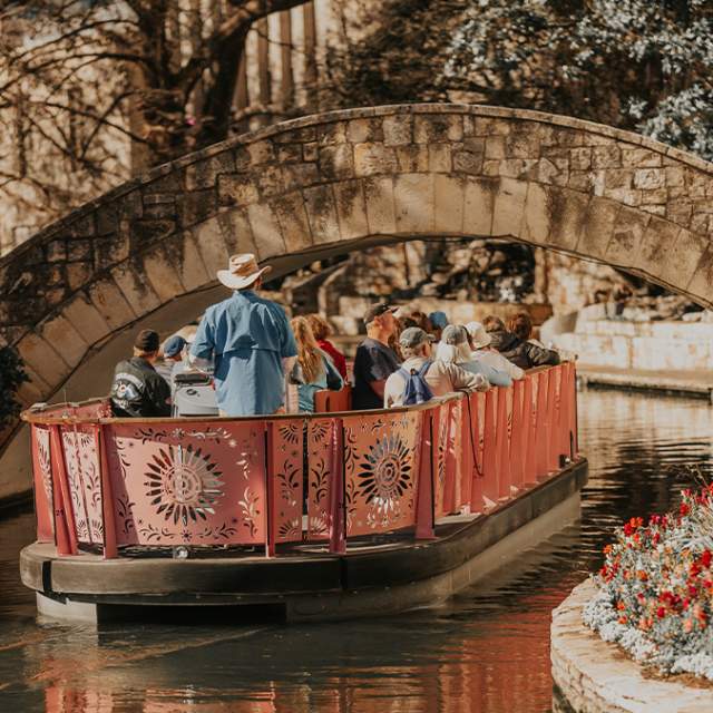 Barge carrying people floating down River Walk