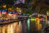 Calm river along River Walk with holiday lights and patio dining in background