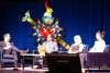 staff discussing on a panel on a stage