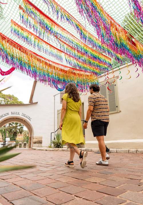 Couple walking in La Villita under papel picado