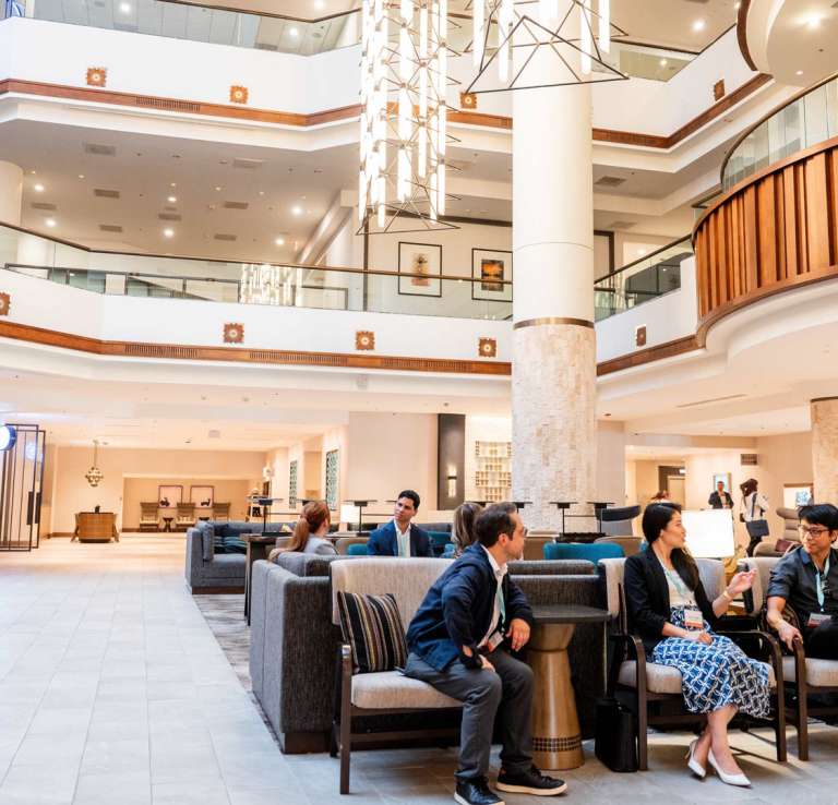 Hotel lobby filled with professionals talking.