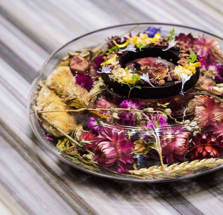 Circular plate of food adorned with florals at Nicosi restaurant in San Antonio.