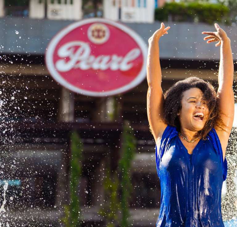 Woman splashing in fountain at Pearl in San Antonio.