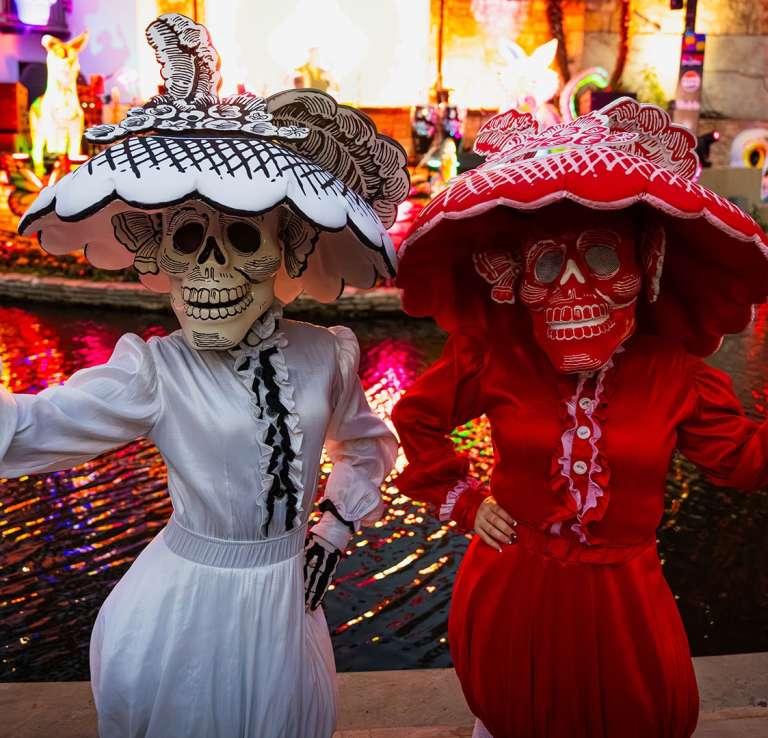 Two people dressed in calavera costumers