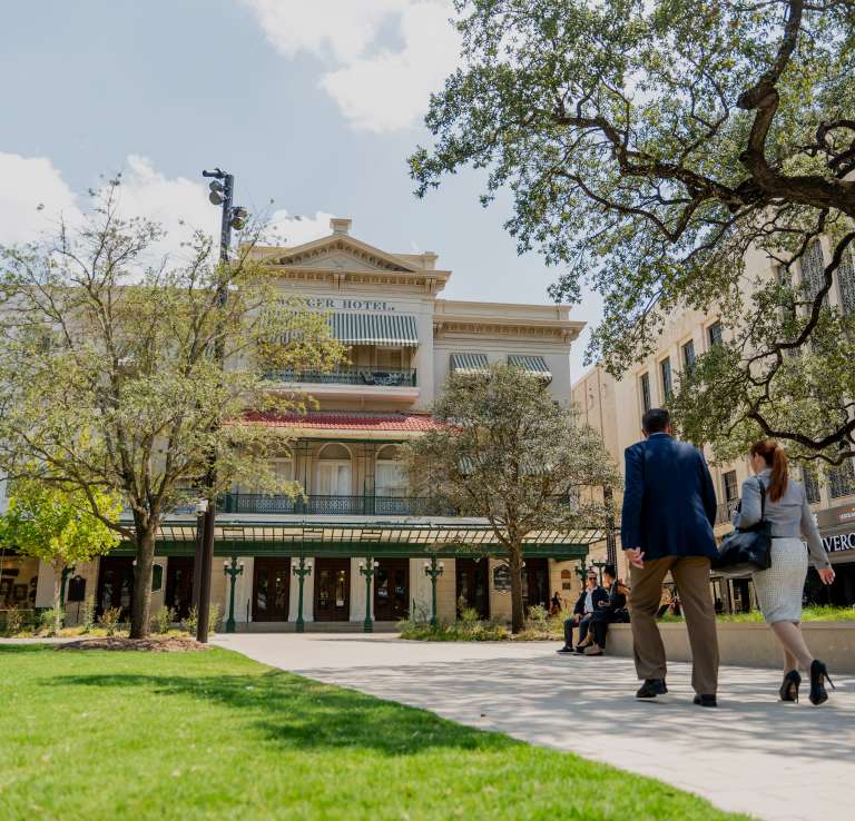People walking outside toward the Menger Hotel in San Antonio.