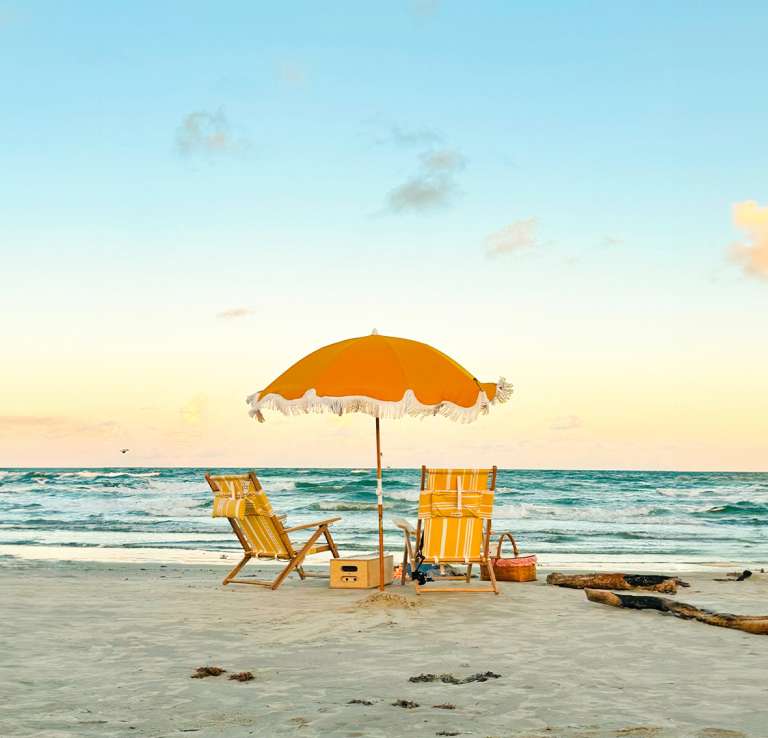 Beach with two yellow chairs and matching yellow umbrella