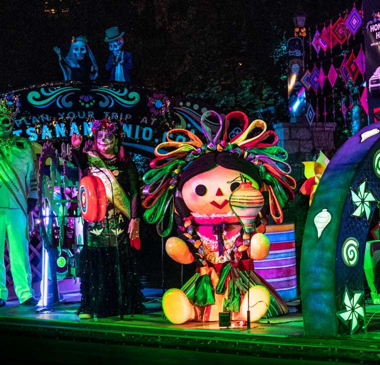 River parade float with people dressed with sugar skulls