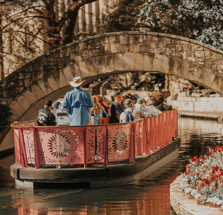 Barge carrying people floating down River Walk