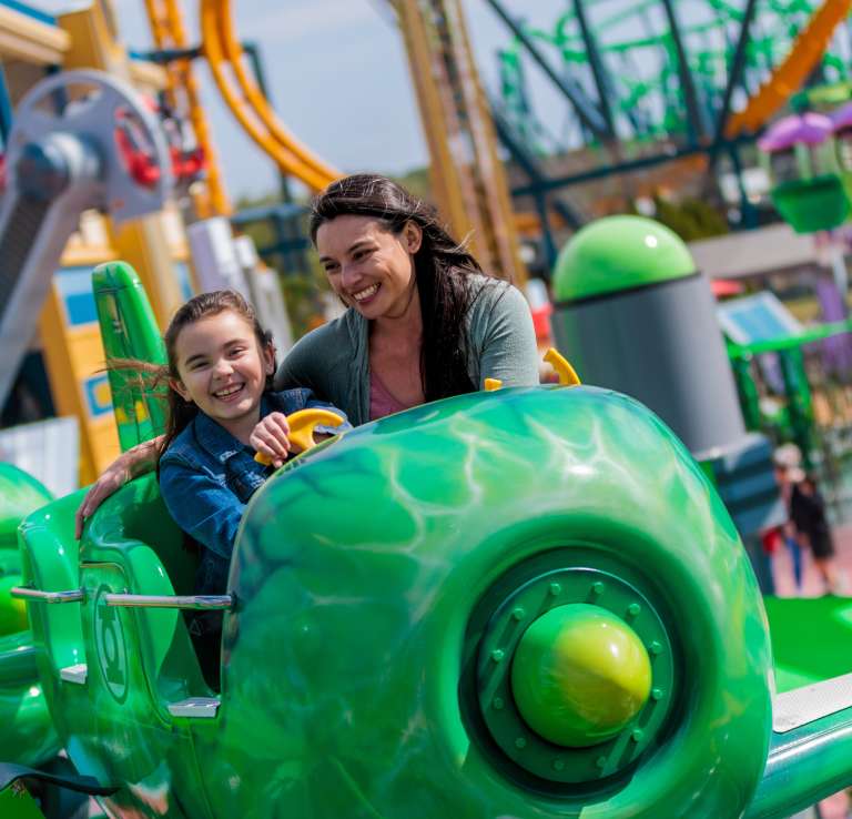Mother and daughter smiling on Green Lantern ride at Six Flags Fiesta Texas.